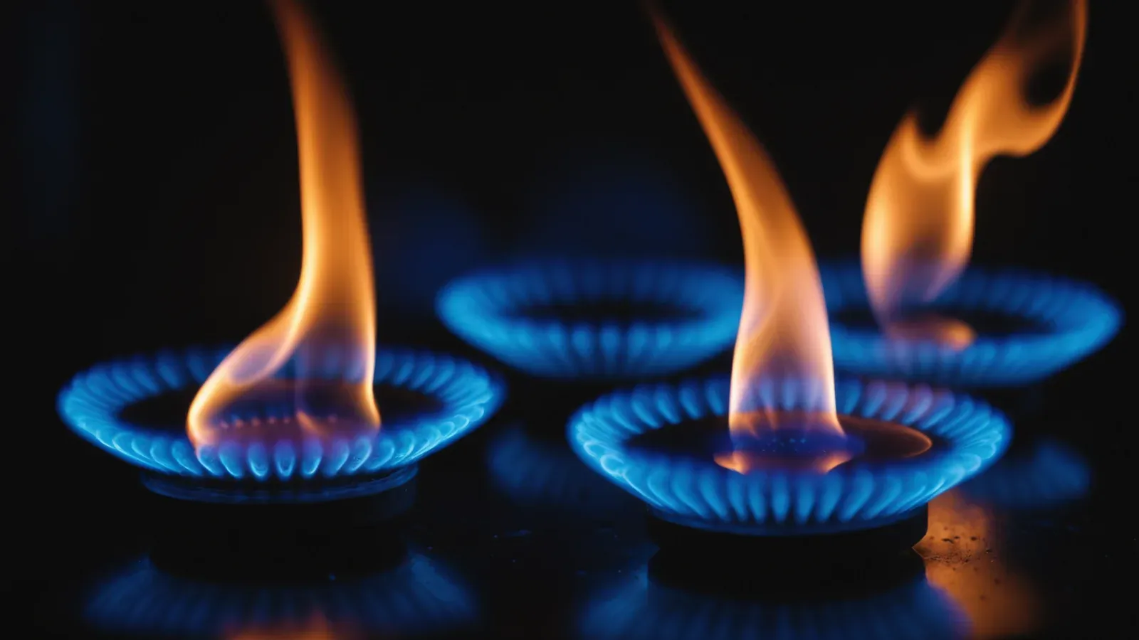 Flammes bleues de gaz vues de côté dans la pénombre, en gros plan